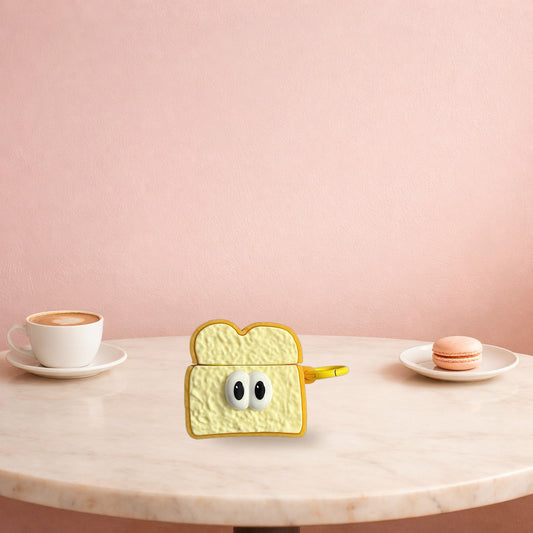 Toast slice AirPods case on a marble cafe table