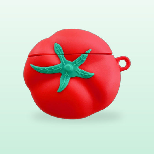 Red tomato AirPods case with a green leaf top and a small loop, on a mint background
