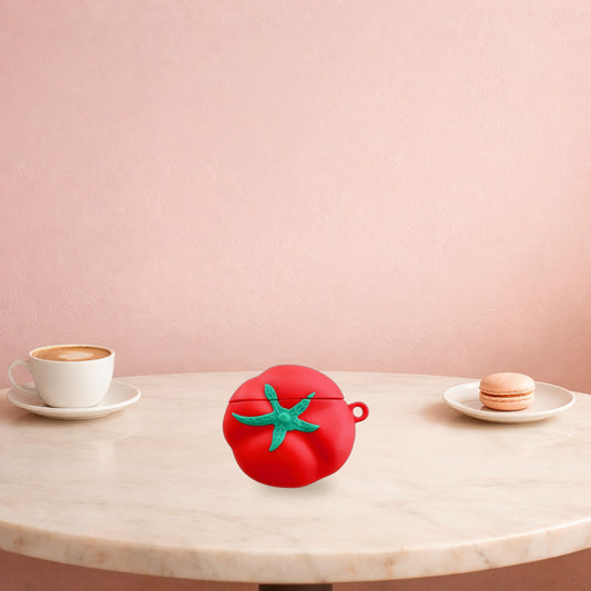 Red tomato AirPods case on a marble cafe table