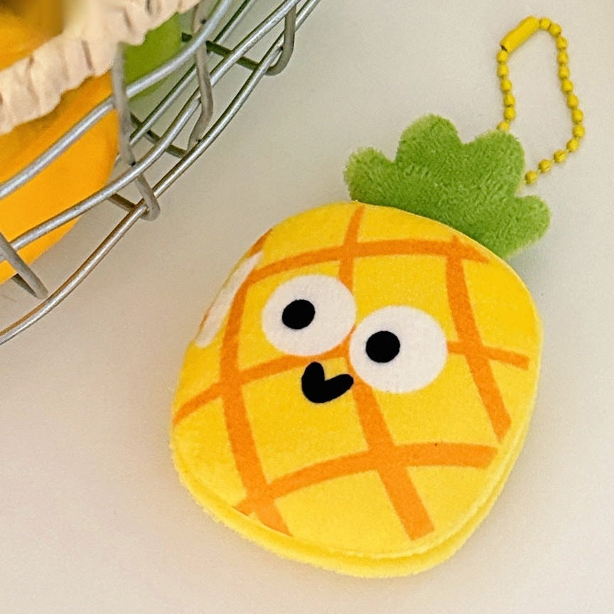 One yellow plush pineapple keychain with orange grid, white cartoon eyes, black smile and yellow bead chain.