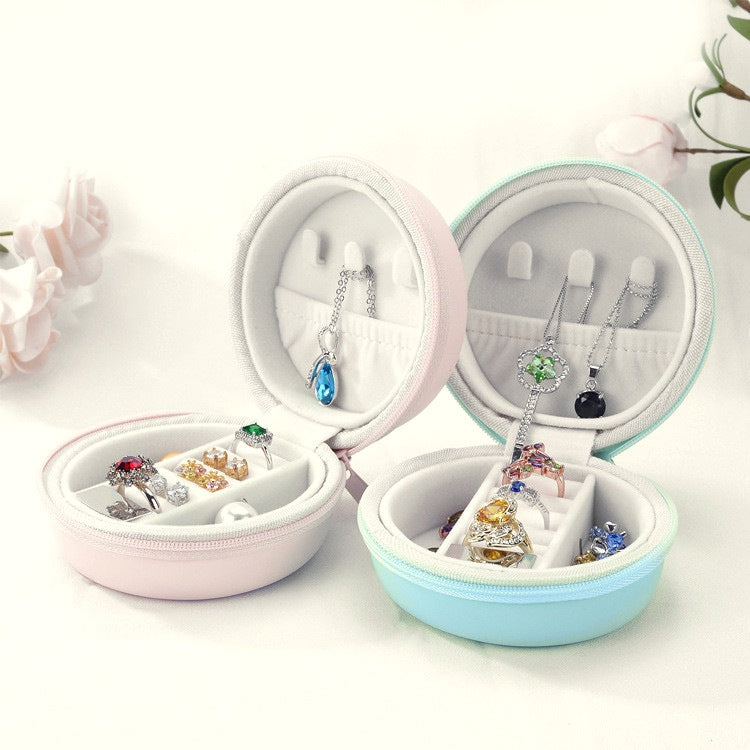 Two macaron jewellery cases open, showing ring rolls, earring slots, necklace hooks and a pocket in the lid