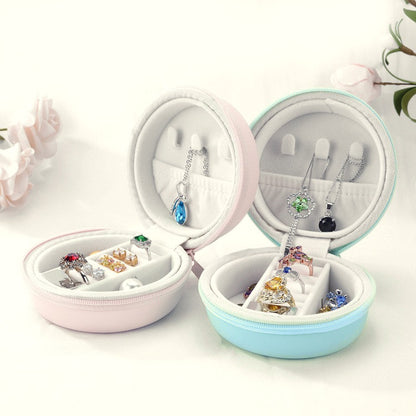 Two macaron jewellery cases open, showing ring rolls, earring slots, necklace hooks and a pocket in the lid