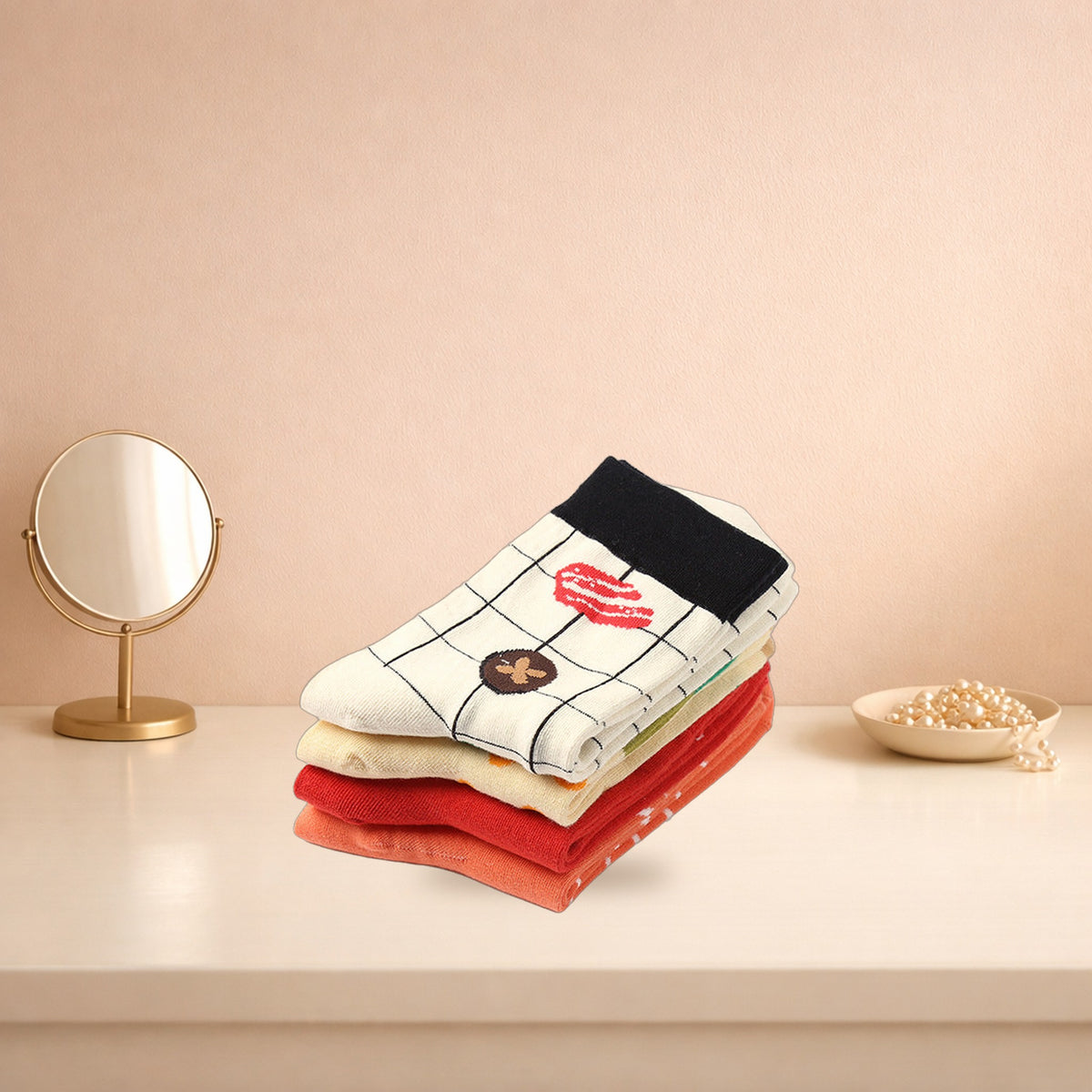 Four folded Japanese food print socks stacked on a cream dressing table